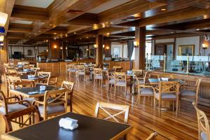 蒙特港abba Presidente Suites Puerto Montt的餐厅铺有木地板,配有桌椅
