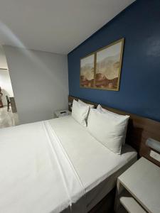 若昂佩索阿Imperial Tambau By Loui的一间卧室配有一张白色大床和蓝色的墙壁