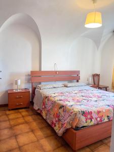 菲纳莱利古雷Orchidea的卧室配有1张床、1张桌子和1把椅子