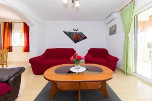 沃希Kuća za odmor Pixie的客厅配有桌子和红色椅子