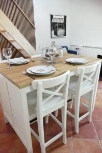 罗佐瓦克Kalpic Suites & Villa的白色的餐桌,配有两把椅子和酒杯