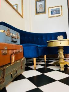 圣地亚哥Hotel Casa Aure的摆在摆在摆在摆弄行李地板上的蓝色沙发
