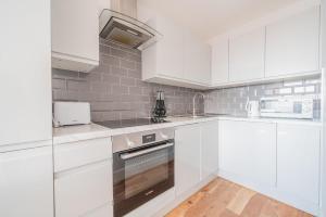 伊斯特雷格Central Eastleigh 1 Bedroom Apartment的白色的厨房配有白色橱柜和电器