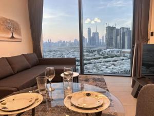 迪拜Dubai World Central Budget Apartments的客厅配有沙发和带酒杯的桌子