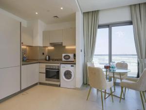 迪拜Dubai World Central Budget Apartments的厨房以及带桌椅的用餐室。