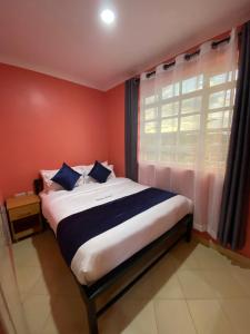 KiambuTodas Hotel的一间卧室设有一张大床和窗户