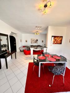 拉马萨Duplex的客厅配有桌子和红色地毯