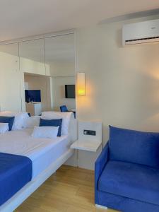 巴统Luxury Batumi Hotel的一间卧室配有一张大床和一张蓝色的沙发