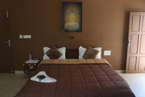 PallipuramSeagreen Beach resort的卧室配有一张大床,墙上挂有绘画作品