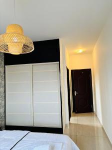 利伯维尔Bienvenue au centre-ville de Libreville的卧室设有白色车库门和吊灯。