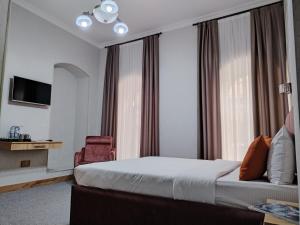 巴库Pera Hotel Baku的配有一张床和一把椅子的酒店客房