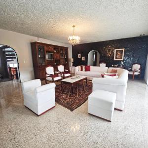 昆卡Casa Hamilton casa entera的客厅配有白色家具和吊灯。