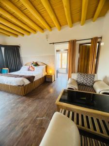 列城Guza Ethnic Resort的大房间设有两张床和一张沙发