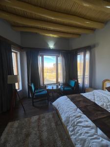 列城Guza Ethnic Resort的卧室配有一张床和一张桌子及椅子