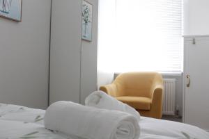 ClaypitsCrossways - Eastington的一间卧室配有椅子和一张带毛巾的床