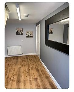 彻克The Little House, Oswestry的客厅设有大镜子和木地板