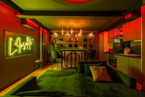 图卢兹L’Insolite, Spa Privatif (Appartement Jacuzzi)的一间带绿色沙发的客厅和一间厨房