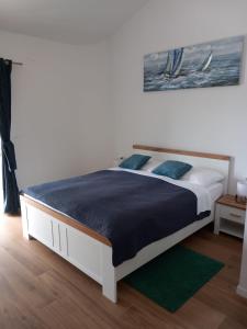 普莱曼图拉Apartmani LUNI的一间卧室配有一张带蓝色枕头的大床