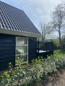 雷讷瑟Ecolodges De Dreef Guesthouse的花园中带窗户的蓝色房子