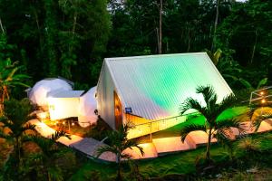 别霍港HOTEL, VILLAS y GLAMPINGS MYA -PUERTO VIEJO, Limon, CR的森林中一座带锡屋顶的大型建筑