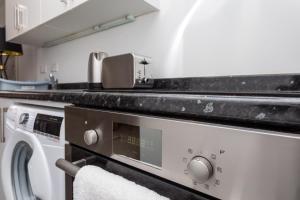 克劳利Flat 5- Cozy Studio Flat in The Heart of Crawley的厨房配有洗衣机和水槽