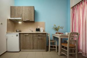 法拉萨纳Kalami apartment in Falasarna的厨房配有白色冰箱和桌子