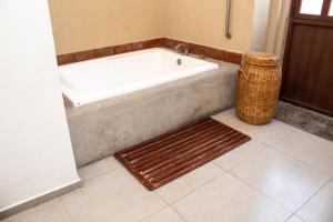 普埃布拉Casa Pepe的浴缸位于带地毯的浴室内