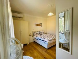 皮兰Villa Verde Piran, Authentic Mediterranean Stay的卧室配有床、椅子和窗户。