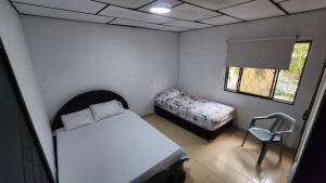 巴兰基亚APARTAHOTEL HEFZIBA的一间小卧室,配有一张床和一把椅子