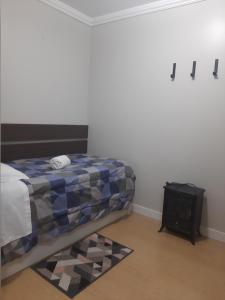 格拉玛多Solar das Esmeraldas - Apto 105的一间卧室配有一张床和一张桌子,铺有地毯