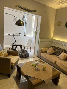 亚喀巴Masa Aqaba Apartments的客厅配有沙发和桌子