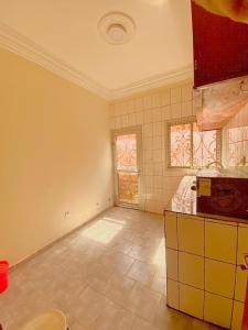雅温得Nicole Residence的一间空厨房,铺有瓷砖地板,设有窗户