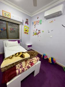 亚喀巴Masa Aqaba Apartment的紫色地毯的客房内一间卧室,配有一张床