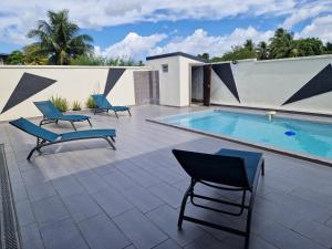 萨莱比梅Villa marigua 2的一个带游泳池、两把椅子和一个游泳池的庭院