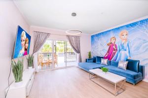 奥兰多Luxury Disney Themed Condo - Pool & Private Patio的客厅配有蓝色沙发和绘画作品