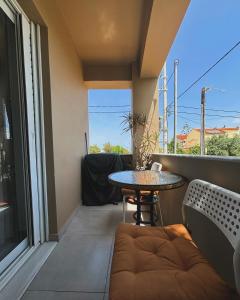 阿特米达Liakada Guest House的小阳台配有桌子和沙发