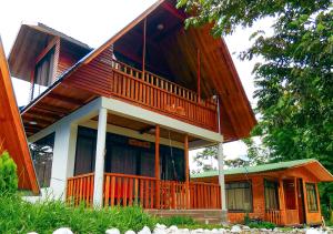 奥克萨潘帕Kusi Lodge的大型木制房屋设有大阳台