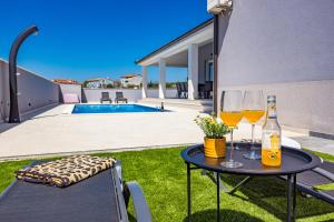 罗波里卡Villa Tea with heated pool的院子顶上一张桌子和两杯葡萄酒