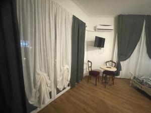热那亚凯沃尔16号住宿加早餐旅馆的配有桌子、两把椅子和窗帘的房间