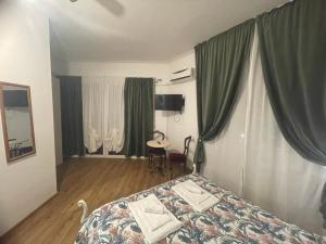 热那亚凯沃尔16号住宿加早餐旅馆的一间卧室配有一张带绿色窗帘的床和一张桌子