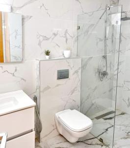 塔格梅斯Gan eden的白色的浴室设有卫生间和淋浴。
