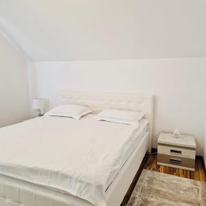 勒德乌齐Adonis Oasis Rădăuți的白色卧室配有白色的床和床头柜