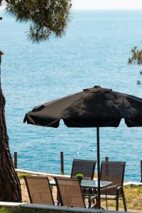 阿利基Acroterra - Easy Living的水边雨伞下的桌椅