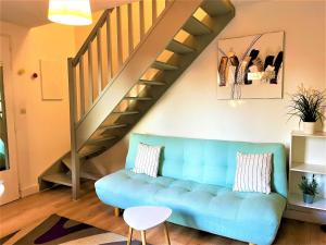 卡尔萨克阿亚克CAPORIZON-Carsac-Piscine-Gite Périgord Sarlat-Clim的客厅设有蓝色的沙发和楼梯。
