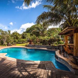 安加罗阿Hotel Chez Maria Goretti的棕榈树度假村内的游泳池