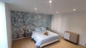 讷韦尔Résidence du Palais的卧室配有白色的床和树壁画