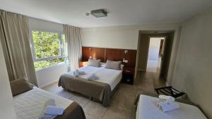 马德普拉塔Hotel Novi的酒店客房设有两张床和窗户。