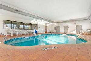 太平洋六旗圣路易斯附近康福特茵酒店的一个带桌椅的大型游泳池