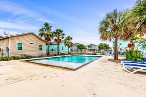 罗克波特The Captain's Quarters的一座棕榈树游泳池和一座房子