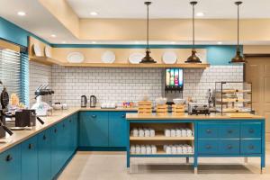 什里夫波特Country Inn & Suites by Radisson, Shreveport-Airport, LA的厨房配有蓝色橱柜和白色瓷砖